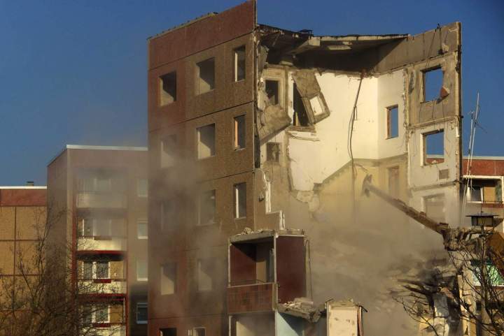 Engin de démolition avec un bras articulé effectuant des coupes chirurgicales sur une structure en béton, minimisant les risques pour lenvironnement.